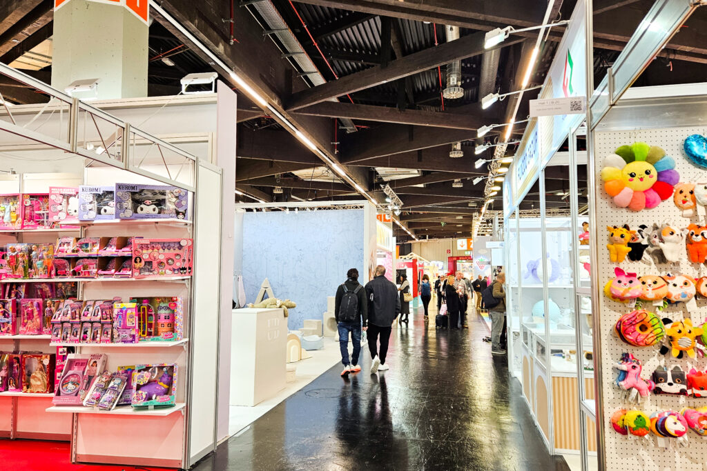 Messehalle der Spielwarenmesse Nürnberg mit Ausstellungsständen, Spielzeugprodukten und Besuchern im Gangbereich